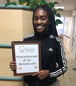Young woman holding cavity-free club sign